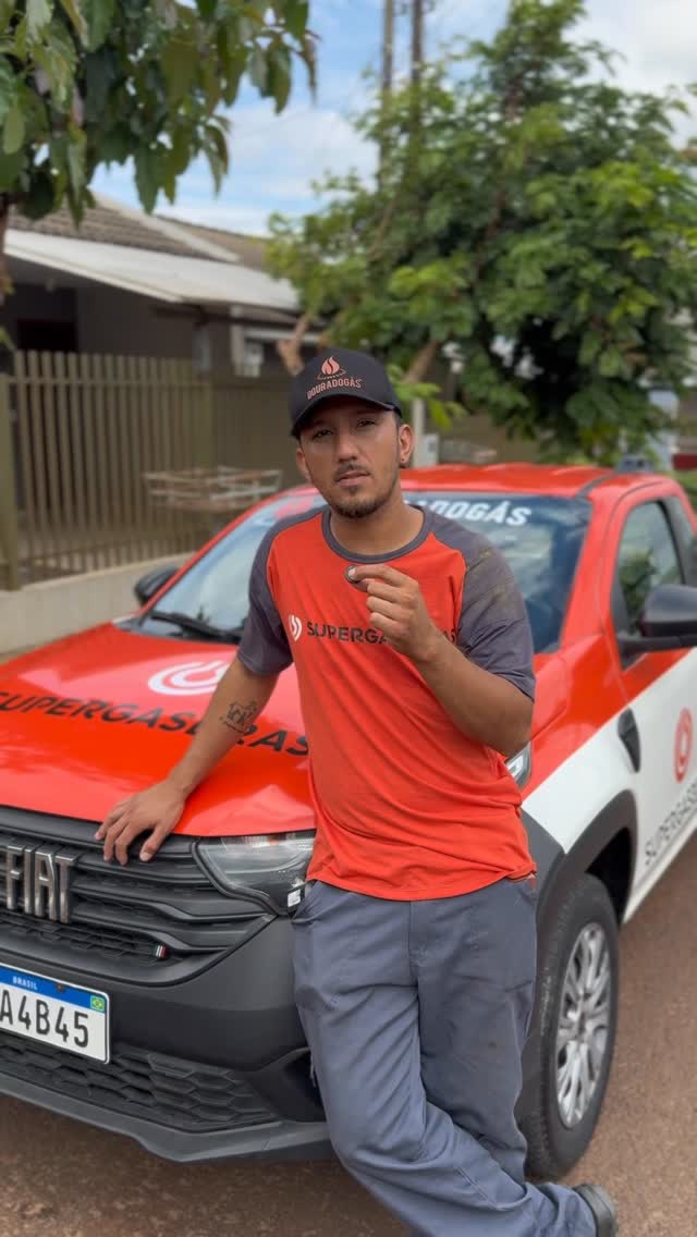 Entregador uniformizado ao lado do veículo da Dourado Gás.